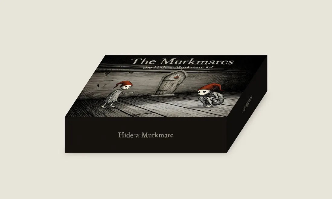 The kit box, closed: a dark lid showing a tiny wooden door in a skirting board with two Murkmares beside it