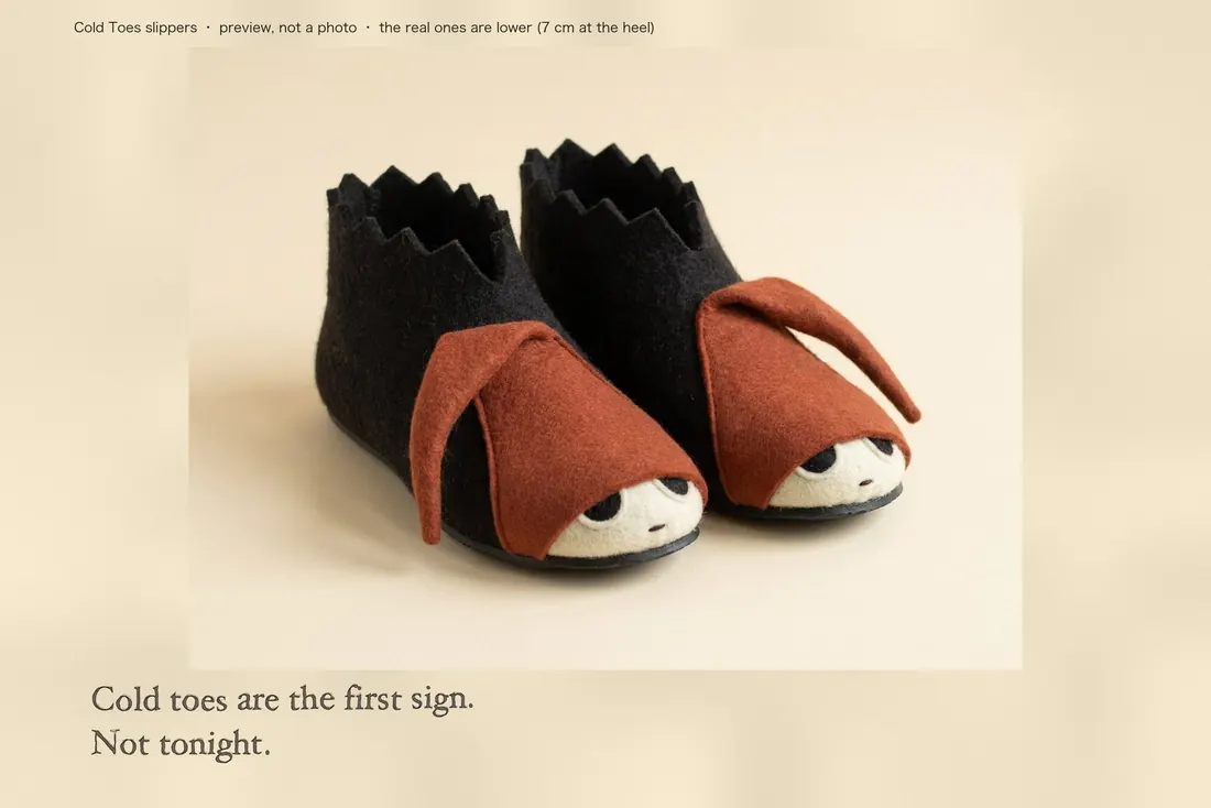 A pair of charcoal felt slippers, each with a floppy rust felt hat over the front and a pale face with black eyes at the toe